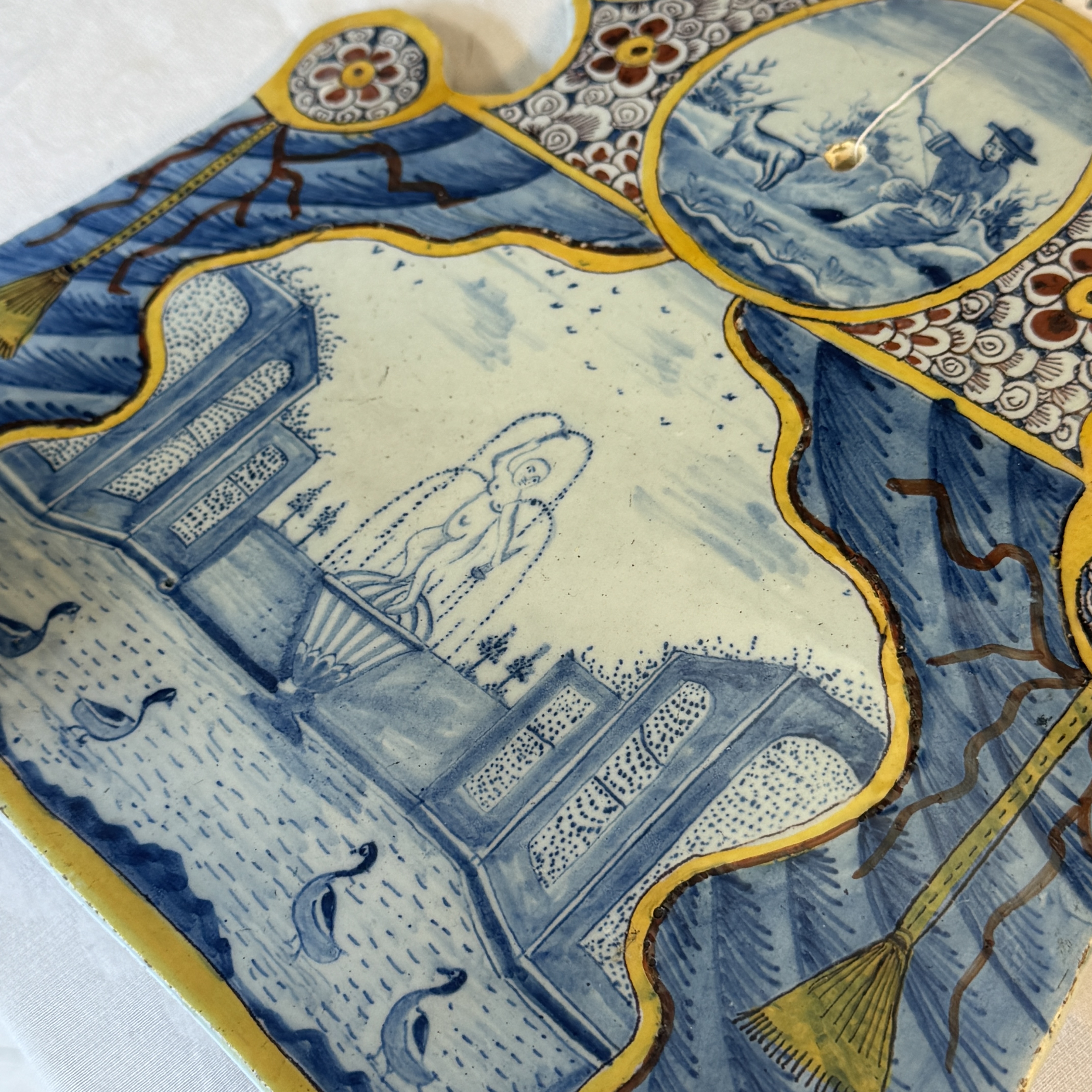 A polychrome Dutch Delft trompe-l'oeil plaque with a fountain garden in a theatrical curtain frame — foto 2