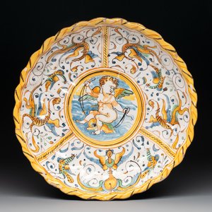 A polychrome Italian maiolica crespina with a putto on a dolphin, Deruta, 17th C. — photo 1