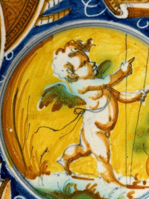A polychrome Italian maiolica plate with a putto surrounded by trophies, Pesaro, 16th C. — photo 2