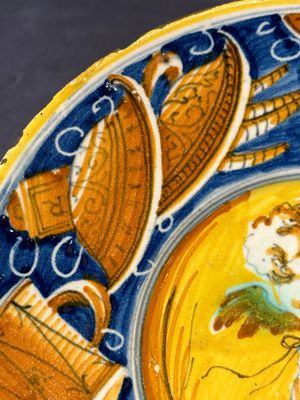 A polychrome Italian maiolica plate with a putto surrounded by trophies, Pesaro, 16th C. — photo 3