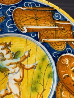 A polychrome Italian maiolica plate with a putto surrounded by trophies, Pesaro, 16th C. — photo 4
