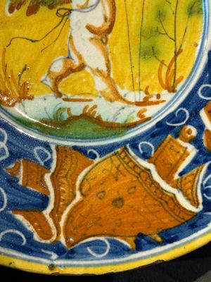 A polychrome Italian maiolica plate with a putto surrounded by trophies, Pesaro, 16th C. — photo 6