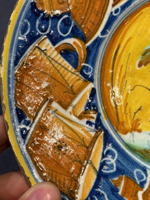 A polychrome Italian maiolica plate with a putto surrounded by trophies, Pesaro, 16th C. — photo 7