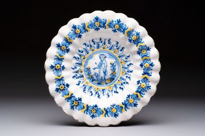 A polychrome lobed Dutch Delft 'Compendario' dish with a shepherd with his dog, 17th C.