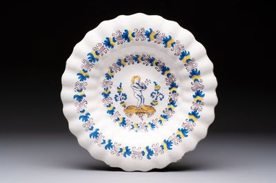 A polychrome lobed Dutch Delftware dish with a putto smoking a pipe, probably Verstraeten workshop, Haarlem, 17th C.