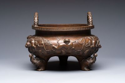 A rare Chinese bronze tripod censer with relief mythical animal and grape design, Xuande mark, 19th C.