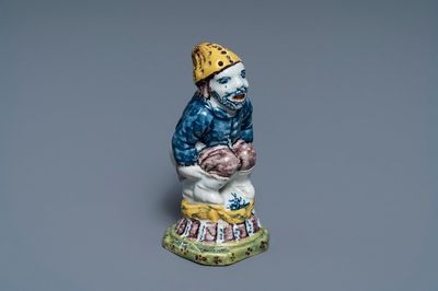 A rare polychrome Dutch Delft caster in the shape of a pooping man, 18th C.