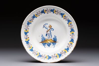 A rare polychrome Dutch Delftware 'Compendario' dish with an arching putto, probably Verstraeten workshop, Haarlem, 17th C.