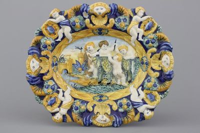 A relief-moulded polychrome oval dish with putti dehorning a goat, 18/19th C.
