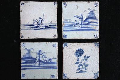 A set of 4 Delft blue and white tiles with various scenes, possibly Lille or Ghent, 17th C.
