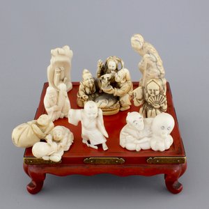 A set of 9 small Japanese ivory carvings, incl. netsuke, on a small red lacquer table, 19th/early 20th C. — 照片 1