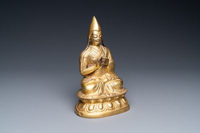 A Sino-Tibetan gilt bronze figure of a lamaic official or dignitary, probably 16th C.