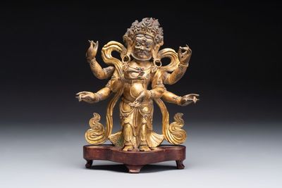 A Sino-Tibetan gilt-bronze figure of White Mahakala on wooden stand, 18th C.