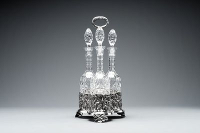 A sterling silver tantalus with three crystal-cut bottles and stoppers, 19/20th C.