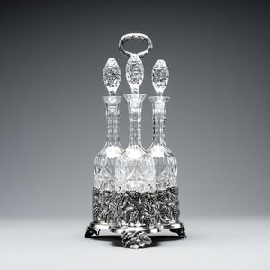 A sterling silver tantalus with three crystal-cut bottles and stoppers, 19/20th C. — photo 1
