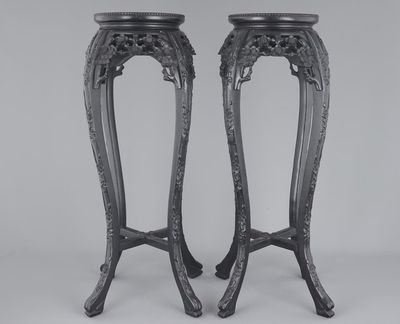 A tall pair of Chinese carved stands with marble top, 19th C.