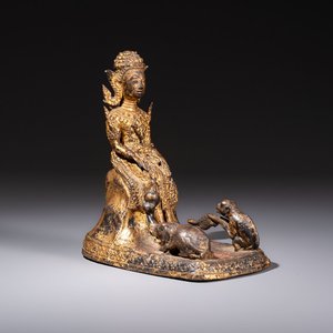A Thai gilt-bronze figure of a seated deity with attendant animals, 19th C. — photo 1