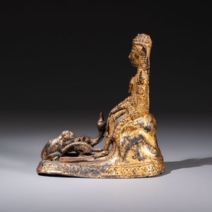 A Thai gilt-bronze figure of a seated deity with attendant animals, 19th C. — photo 3