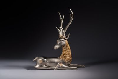 A Thai metal-alloy sculpture of a reclining stag, 20th C.