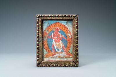 A Tibetan thangka in inlaid gilt brass frame, 19th C.