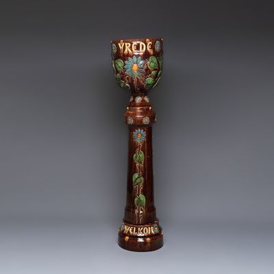 A very large Flemish pottery four-piece jardinière and stand, inscribed 'VREDE' and 'WELKOM', early 20th C.