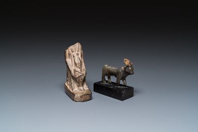 An Egyptian basalt sculpture of a priest or an official holding an Osiris sculpture and a bronze Apis, Late period