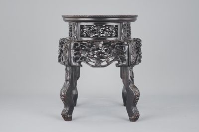 An elaborately carved Chinese hardwood vase stand with dreamstone insert, 19th C.
