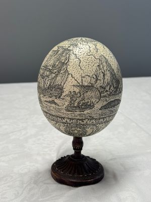 An engraved ostrich egg with a maritime scene on a wooden stand — photo 1