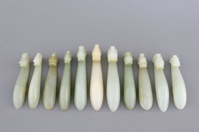 An interesting collection of 11 white and pale celadon jade belt hooks, 19th C.