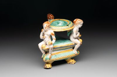 An Italian maiolica triangular salt with winged cherubs, Deruta, 17th C.