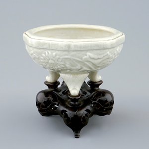An octagonal Chinese celadon tripod censer on carved wooden base, impressed Qianlong mark, 19th C. — photo 1