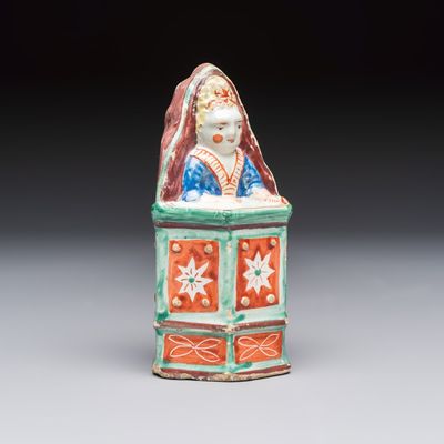 An unusual polychrome Dutch Delft model of a child in a highchair, 18th C.