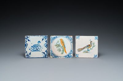 Deux carreaux à décor d'un perroquet et d'un paon en faïence de Delft polychrome et un à décor d'un oie en bleu et blanc, 17ème