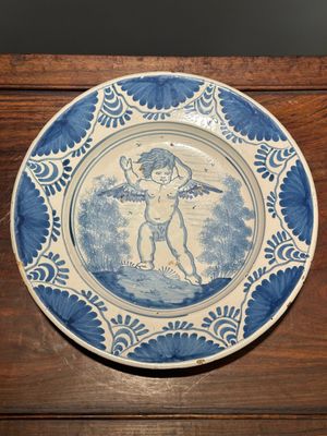 Een aantrekkelijke Nederlandse blauw-witte majolica schotel met een gevleugelde cherubijn, waarschijnlijk Harlingen, 2e helft 17e eeuw — foto 1