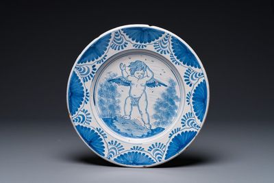 Een aantrekkelijke Nederlandse blauw-witte majolica schotel met een gevleugelde cherubijn, waarschijnlijk Harlingen, 2e helft 17e eeuw