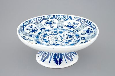 Een blauw-witte Delftse tazza op voet met een putto als valkenier, 18e eeuw