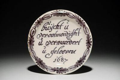 Een blauwwit Delfts spreukbord, gedateerd 1687