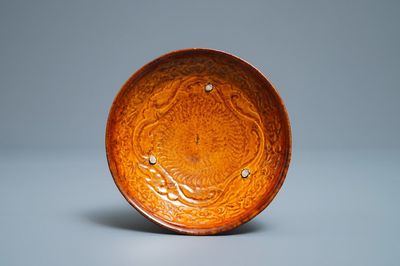 Een Chinees amber geglazuurd bord met reliëfdecor, Liao (916-1125)