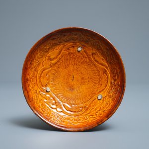 Een Chinees amber geglazuurd bord met reliëfdecor, Liao (916-1125) — foto 1