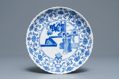 Een Chinees blauwwit gelobd bord met figuren op een terras, Kangxi merk en periode