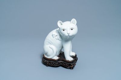 Een Chinees Dehua blanc de Chine model van een kat op houten sokkel, 19e eeuw