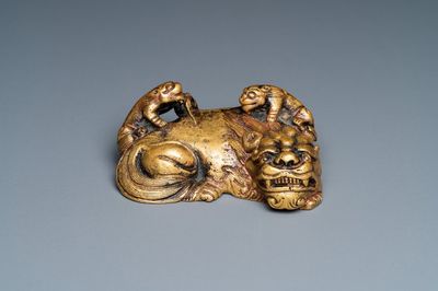 Een Chinees verguld bronzen scrollgewicht met een leeuw met welpjes, Qing