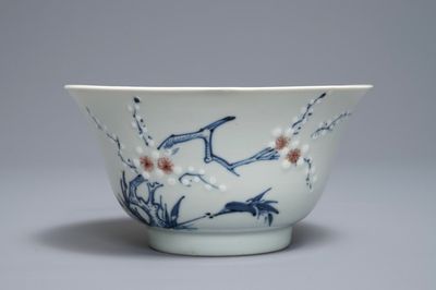 Een Chinese blauwwitte en rode kom met prunustakken op celadon fondkleur, Kangxi