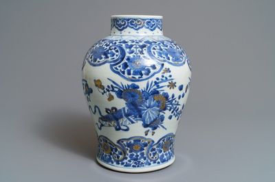 Een Chinese blauwwitte en vergulde vaas met floraal decor, Kangxi