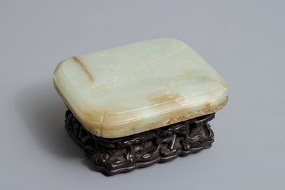 Een Chinese celadon en roest jade dekseldoos op houten sokkel, Ming/Qing