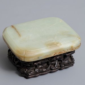 Een Chinese celadon en roest jade dekseldoos op houten sokkel, Ming/Qing — foto 1