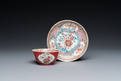 Een Chinese famille rose kop en schotel met robijnrode fondkleur, Yongzheng