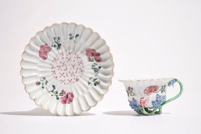 Een Chinese famille rose lotusvormige kop en schotel met reliëfdecor, Yongzheng