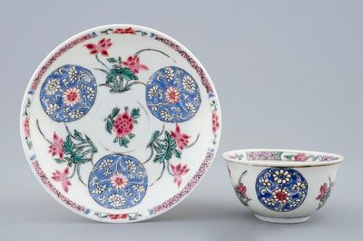Een Chinese famille rose semi-eierschaal kop en schotel met floraal decor, Yongzheng/Qianlong