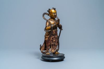 Een Chinese gelakte en vergulde bronzen figuur van een dienaar, Ming